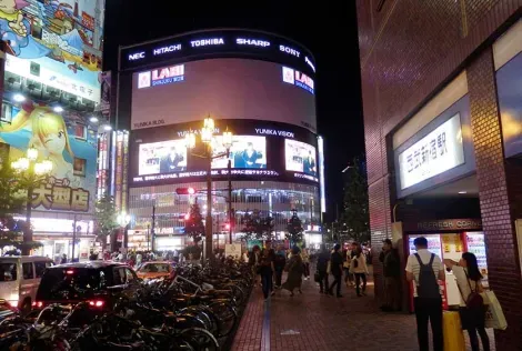 Yunika Building with its video screens in front of the main entrance of Seibu Shinjuku Station